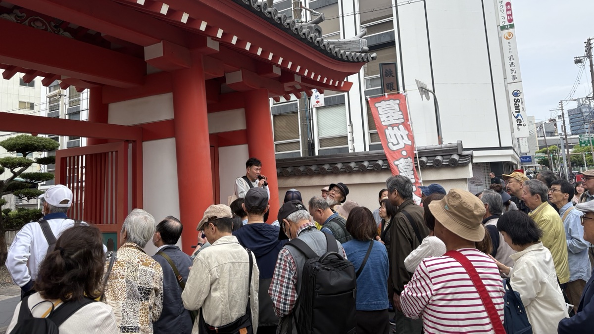 大阪歴史ウォーク2026春。瑞龍寺の山門前でガイドの説明を聞く参加者